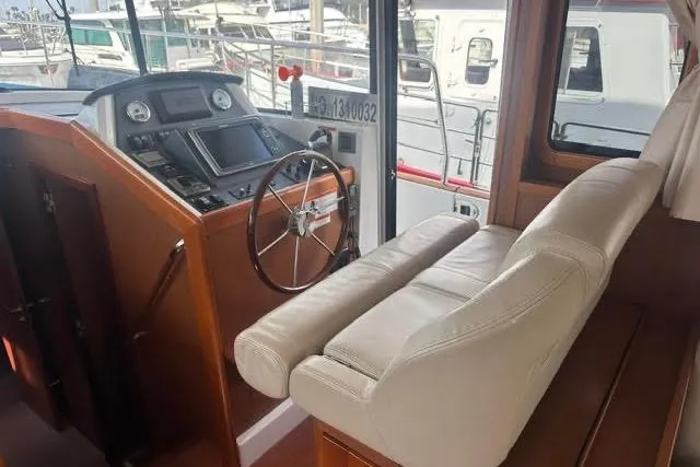 Slide: The Image of 2015 Beneteau Swift Trawler 44 helm with leather seating and navigation controls. - 27