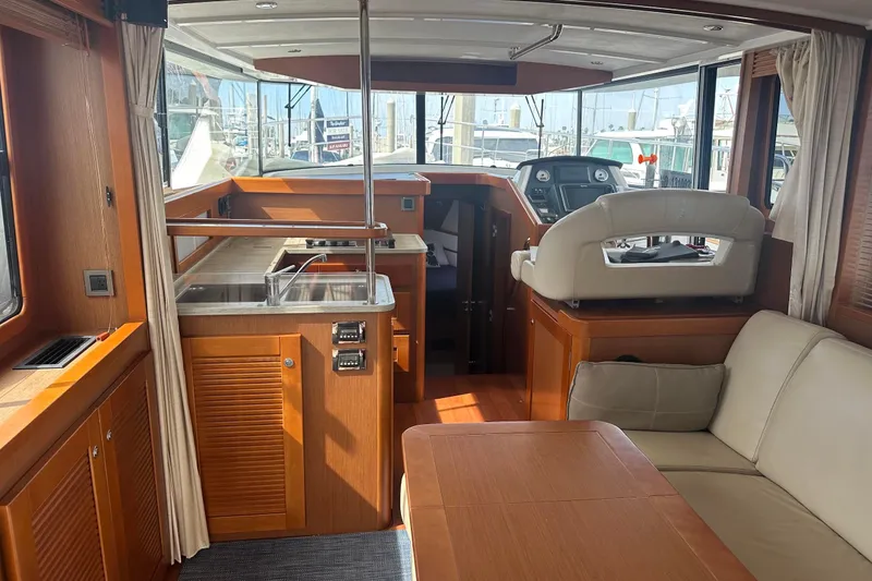 Slide: The Image of Interior of 2015 Beneteau Swift Trawler 44 with helm, seating, and kitchen area. - 30
