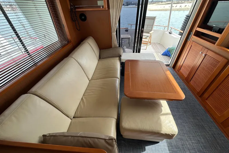 Slide: The Image of Interior of 2015 Beneteau Swift Trawler 44 with beige sofa and wooden table. - 31