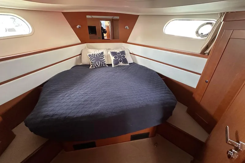 Slide: The Image of Cozy cabin interior of 2015 Beneteau Swift Trawler 44 with bed and portholes. - 34