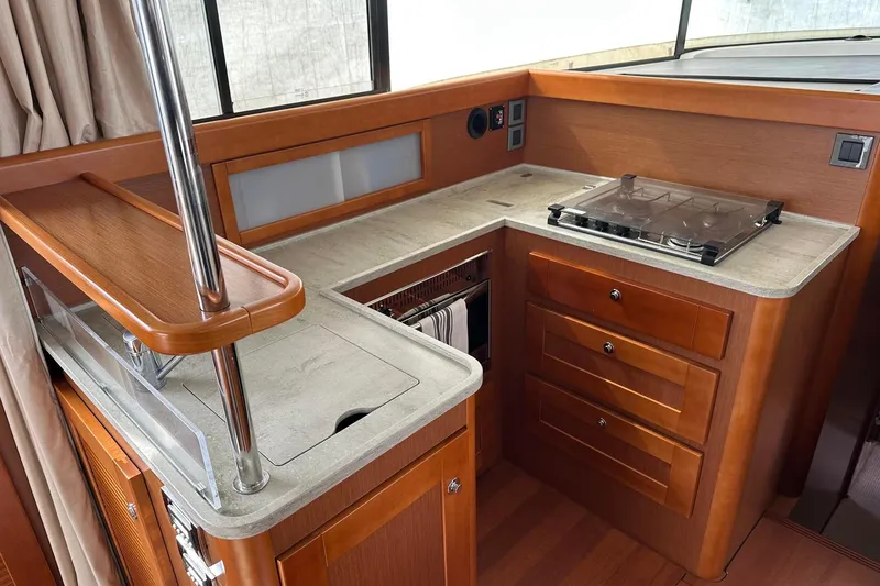 Slide: The Image of Interior of 2015 Beneteau Swift Trawler 44, featuring a compact kitchen area. - 37
