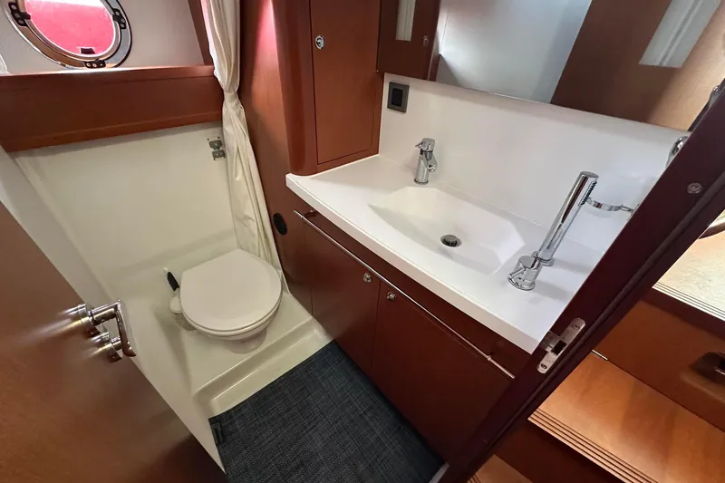 Slide: The Image of 2015 Beneteau Swift Trawler 44 bathroom with sink, toilet, and wooden cabinetry. - 40