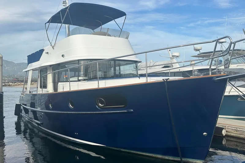 Slide: The Image of 2015 Beneteau Swift Trawler 44 docked, featuring a sleek blue hull and spacious upper deck. - 5