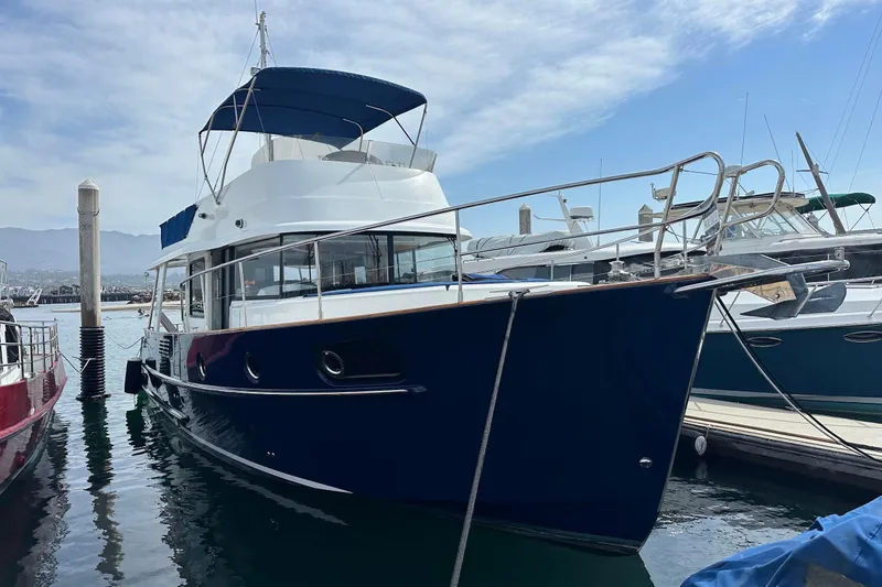 Slide: The Image of 2015 Beneteau Swift Trawler 44 docked at marina under blue sky. - 6