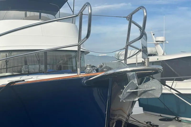 Slide: The Image of 2015 Beneteau Swift Trawler 44 yacht anchored at a marina, showcasing its bow and anchor. - 7