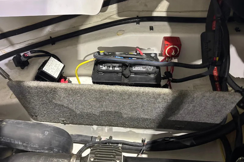 Slide: The Image of 2023 Scarab 165 ID boat battery compartment with wiring and switches. - 16