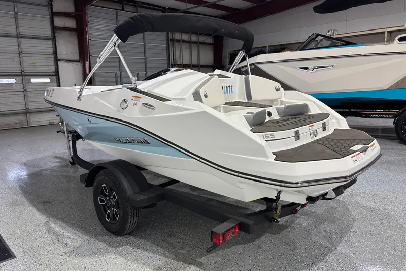 Slide: The Image of 2023 Scarab 165 ID boat on trailer in indoor showroom. - 2