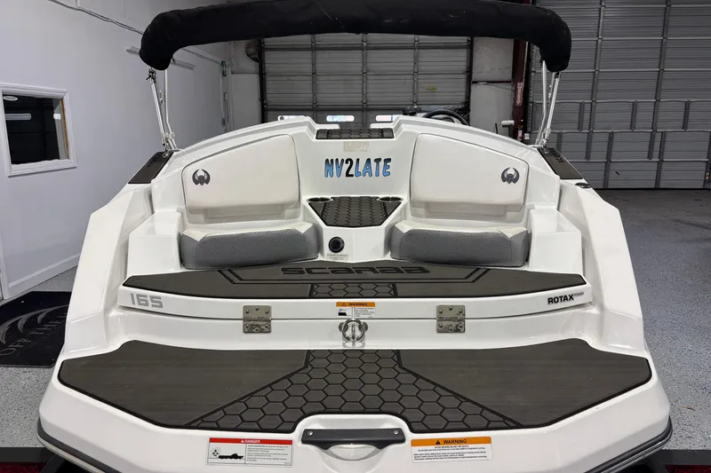 Slide: The Image of 2023 Scarab 165 ID boat rear view in a garage setting. - 3