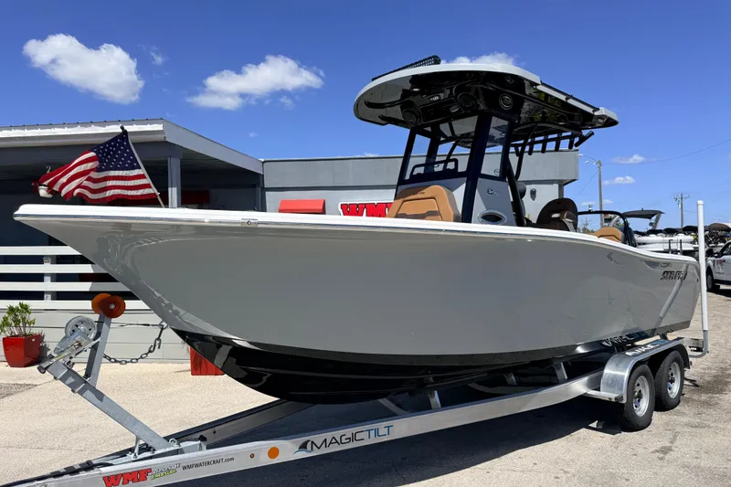 The Image of 2026 Sea Pro 245FLXR Sandbar boat on trailer, American flag, sunny day. - 1