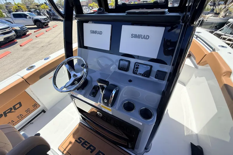Slide: The Image of 2026 Sea Pro 245FLXR Sandbar boat dashboard with Simrad displays and steering wheel. - 16