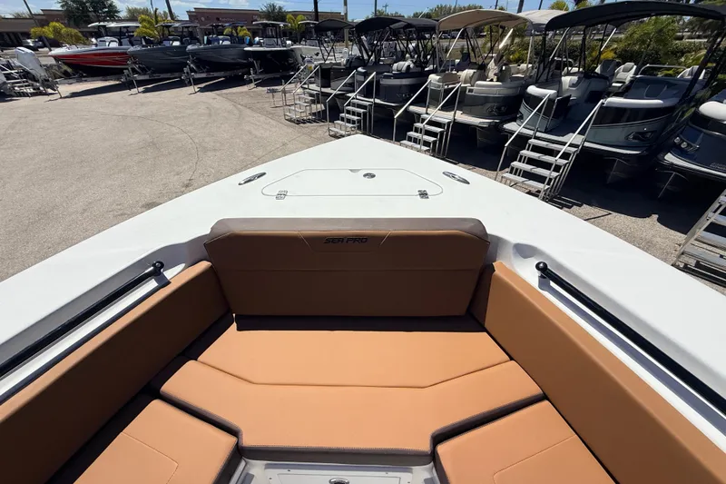Slide: The Image of 2026 Sea Pro 245FLXR Sandbar boat interior with tan seating, docked among other boats. - 19