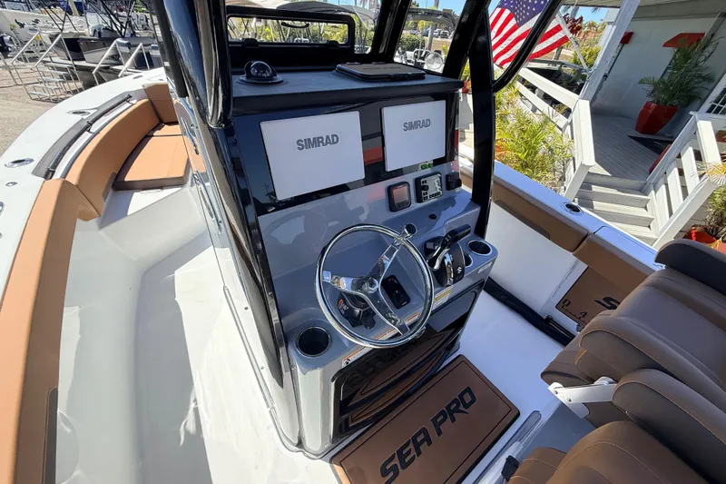 Slide: The Image of 2026 Sea Pro 245FLXR Sandbar boat cockpit with Simrad navigation system and stylish seating. - 24