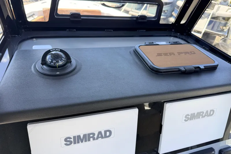 Slide: The Image of 2026 Sea Pro 245FLXR Sandbar dashboard with Ritchie compass and Simrad electronics. - 33