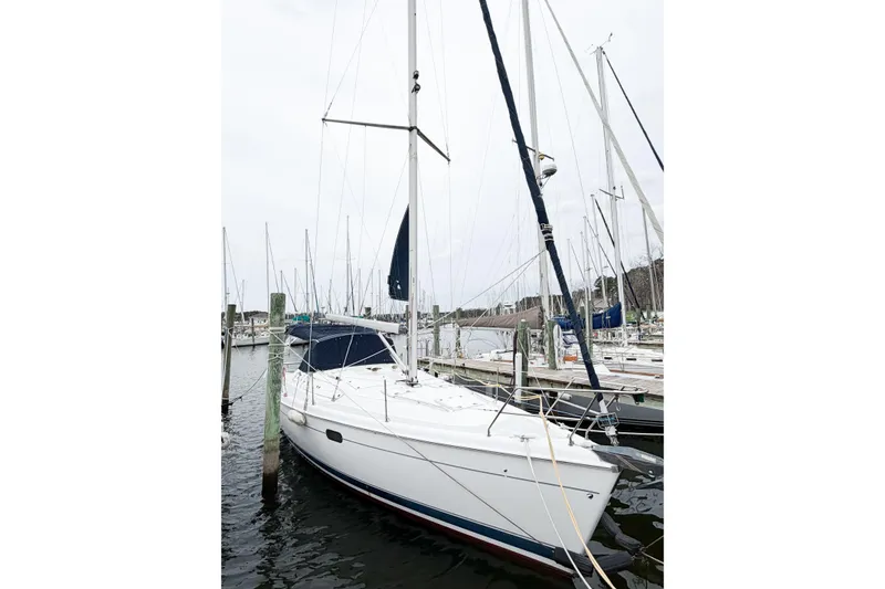 The Image of 2002 Hunter 380 sailboat docked at a marina, featuring white hull and blue accents. - 1