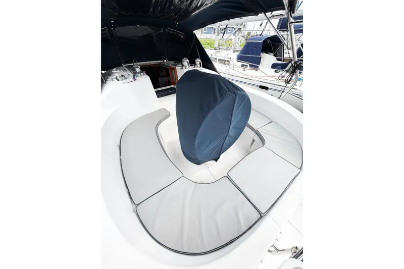 Slide: The Image of Cozy cockpit seating on a 2002 Hunter 380 sailboat, featuring cushioned benches and a covered helm. - 10