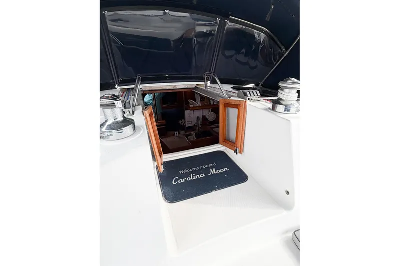 Slide: The Image of Hunter 380 sailboat cockpit entrance, featuring a welcome mat and open wooden doors, 2002 model. - 11