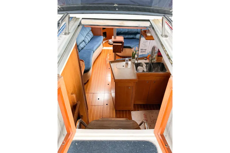 Slide: The Image of Interior view of a 2002 Hunter 380 sailboat, featuring a cozy kitchen and seating area. - 14