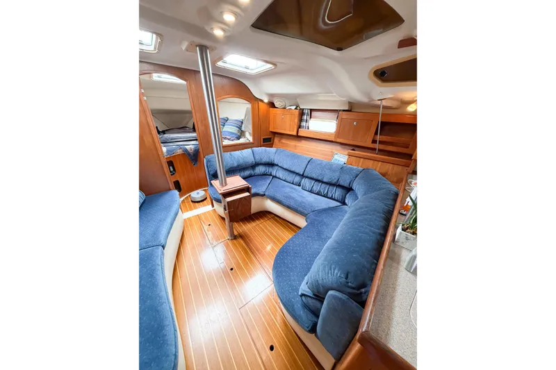 Slide: The Image of Interior of 2002 Hunter 380 sailboat with blue seating and wooden finishes. - 16