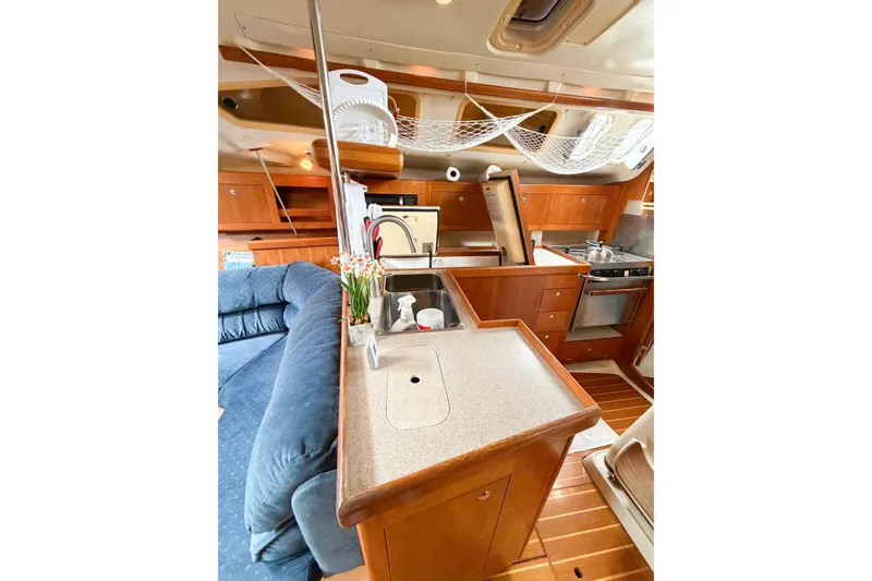 Slide: The Image of Interior of a 2002 Hunter 380 sailboat featuring a cozy kitchen and seating area. - 17