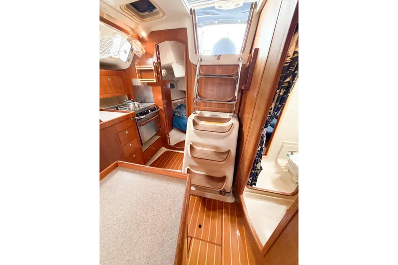 Slide: The Image of Interior of 2002 Hunter 380 sailboat with wooden cabinetry and compact kitchen area. - 19