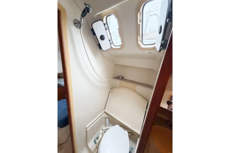 Slide: The Image of Compact bathroom in a 2002 Hunter 380 sailboat with shower and portholes. - 23