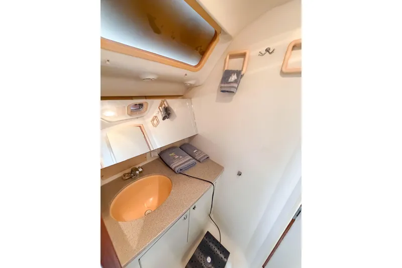 Slide: The Image of Compact bathroom interior of 2002 Hunter 380 yacht with sink and mirror. - 25