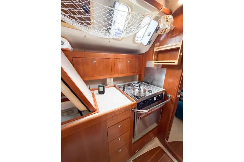 Slide: The Image of Compact kitchen in 2002 Hunter 380 sailboat with stove, cabinets, and net storage. - 27