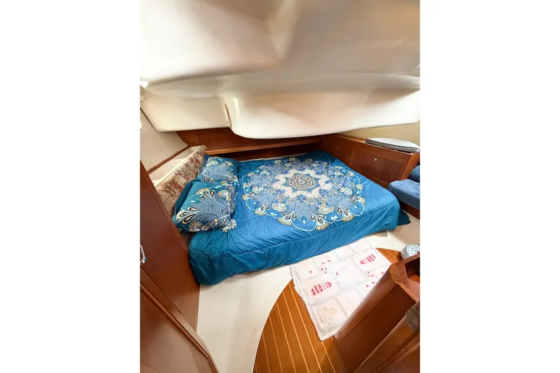 Slide: The Image of Cozy cabin interior of 2002 Hunter 380 yacht with blue bedding and wooden accents. - 29