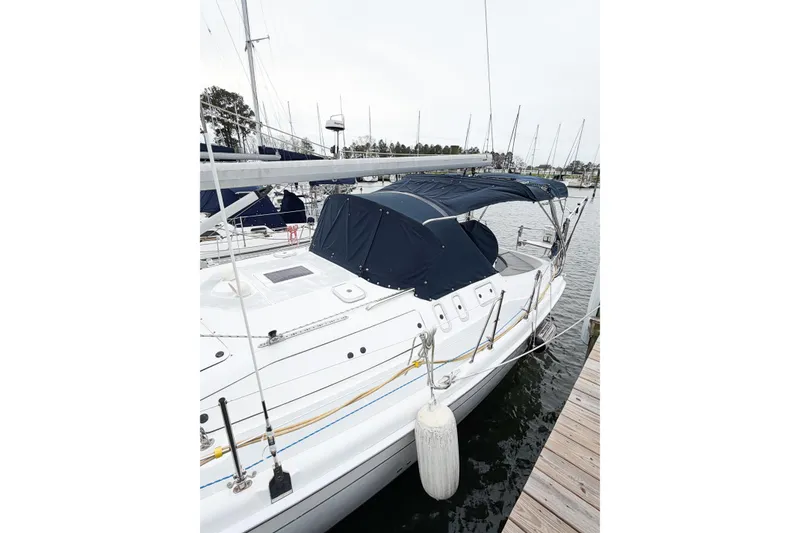 Slide: The Image of Hunter 380 sailboat from 2002 docked, featuring a blue canopy and sleek design. - 3