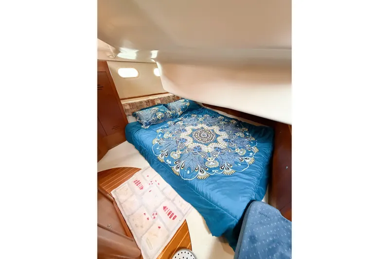 Slide: The Image of Cozy cabin interior of 2002 Hunter 380 sailboat with blue patterned bedding. - 30