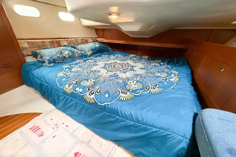 Slide: The Image of Cozy cabin interior of 2002 Hunter 380 yacht with blue patterned bedding. - 31