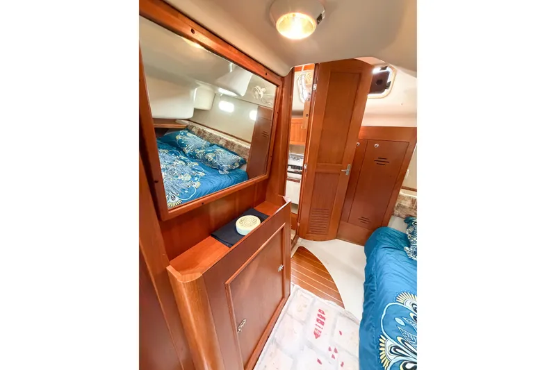 Slide: The Image of Interior of 2002 Hunter 380 yacht with wooden cabinetry and cozy bedding. - 32