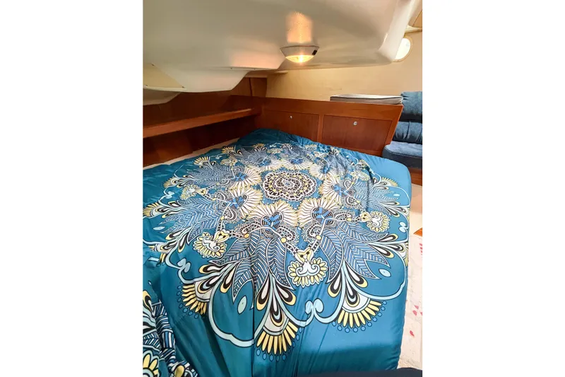 Slide: The Image of Cozy cabin interior of 2002 Hunter 380 yacht with vibrant blue patterned bedding. - 33