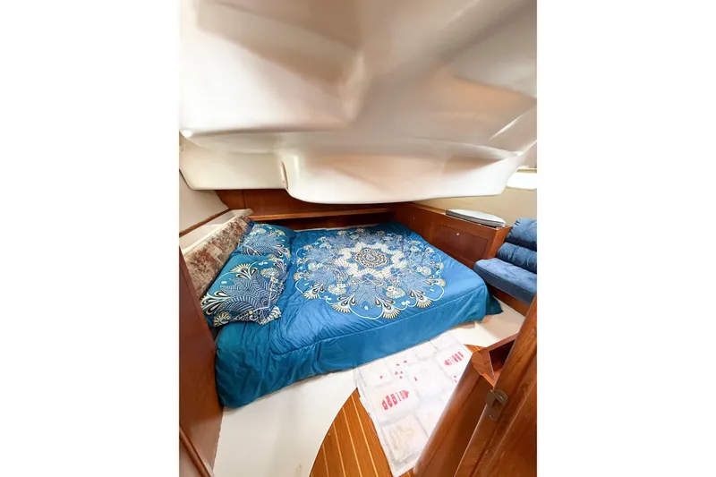 Slide: The Image of Cozy cabin interior of 2002 Hunter 380 sailboat with blue bedding and wooden accents. - 35