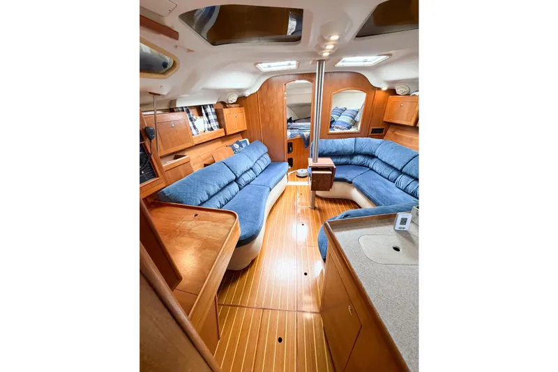 Slide: The Image of Interior of 2002 Hunter 380 sailboat with blue seating and wooden finishes. - 37