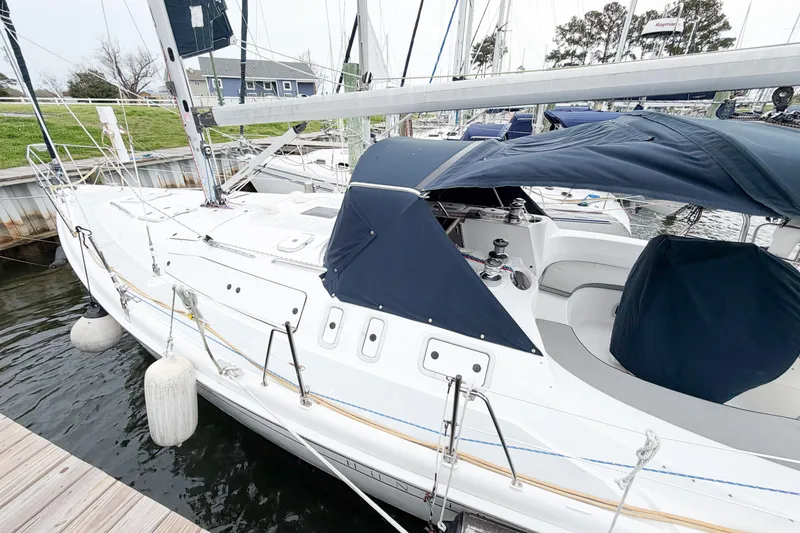 Slide: The Image of Sailboat docked at marina, Hunter 380 model, 2002, with blue canopy and white hull. - 4
