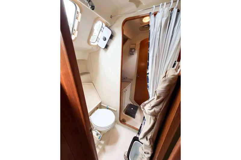 Slide: The Image of Interior of 2002 Hunter 380 sailboat bathroom with toilet and shower curtain. - 43