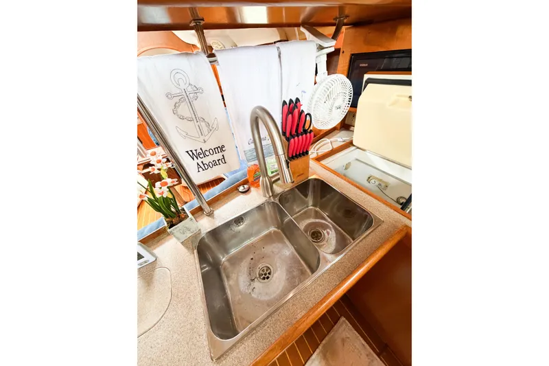 Slide: The Image of 2002 Hunter 380 yacht kitchen with dual sink, welcome towel, and knife set. - 44