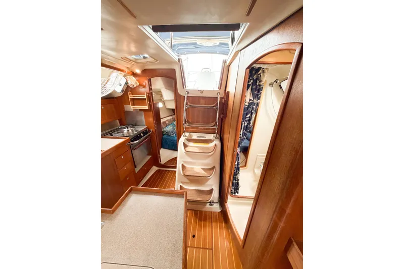 Slide: The Image of Interior of 2002 Hunter 380 sailboat featuring kitchen, stairs, and cozy cabin space. - 50