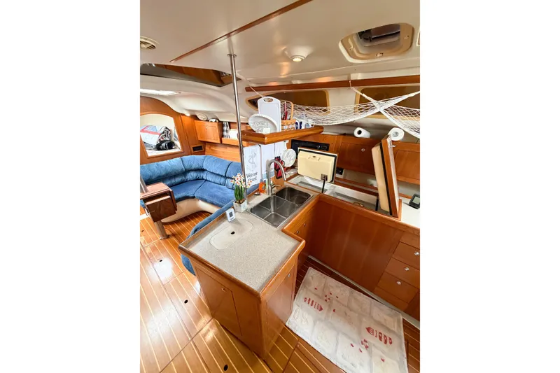 Slide: The Image of Interior of 2002 Hunter 380 sailboat with cozy seating and well-equipped kitchen area. - 51