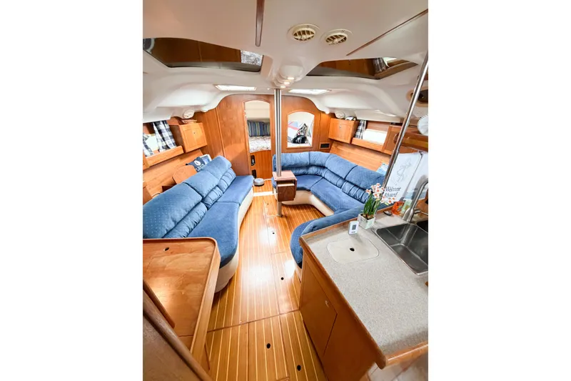 Slide: The Image of Luxurious interior of a 2002 Hunter 380 yacht with blue seating and wooden finishes. - 53