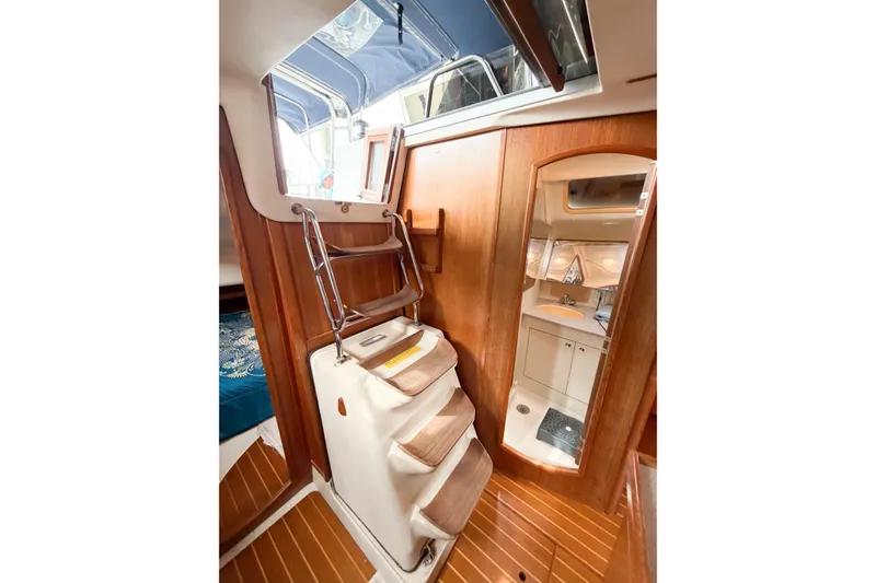 Slide: The Image of Interior of 2002 Hunter 380 sailboat with wooden stairs and compact bathroom. - 54