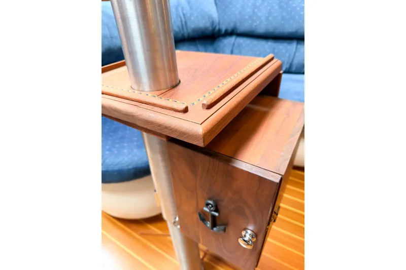 Slide: The Image of Wooden interior detail of a 2002 Hunter 380 sailboat with metal pole and blue seating. - 57