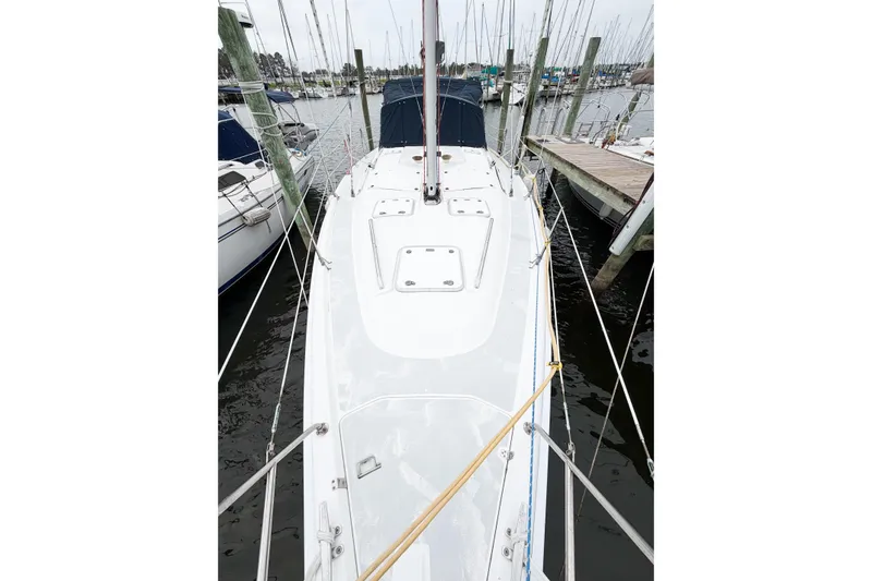 Slide: The Image of 2002 Hunter 380 sailboat docked at marina, showcasing sleek deck design. - 6