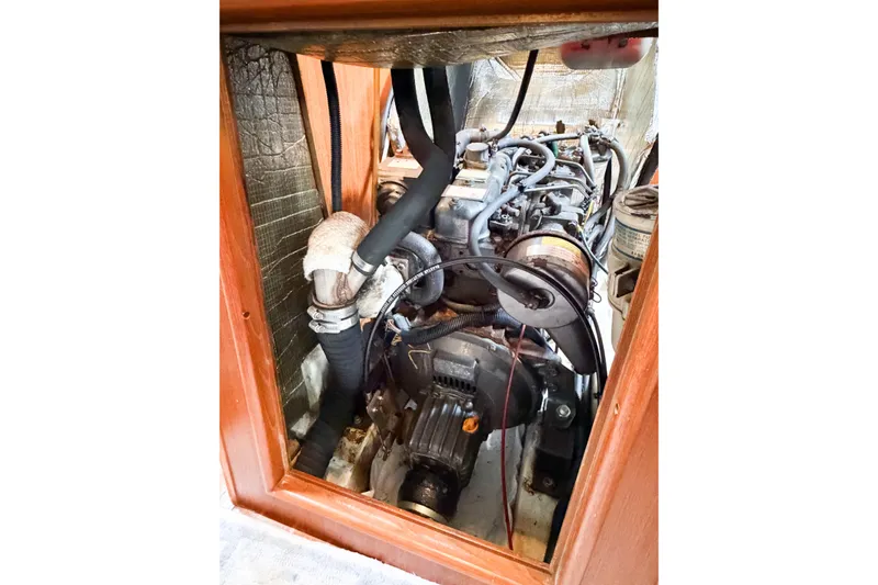 Slide: The Image of Engine compartment of a 2002 Hunter 380 sailboat, showcasing mechanical components and hoses. - 65