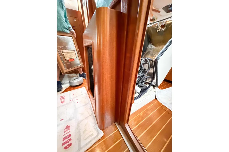 Slide: The Image of Interior view of a 2002 Hunter 380 sailboat, showcasing wooden paneling and engine compartment. - 66