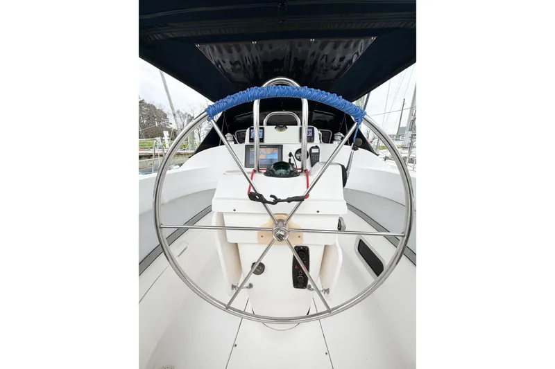 Slide: The Image of Steering wheel of a 2002 Hunter 380 sailboat, featuring navigation instruments and a covered cockpit. - 69