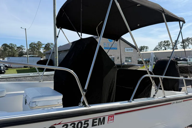Slide: The Image of 2015 Boston Whaler 170 Montauk boat with canopy, parked outdoors near dealership. - 26