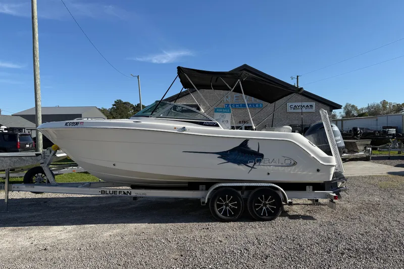 The Image of 2015 Robalo R227 Dual Console boat on trailer, parked outdoors. - 1