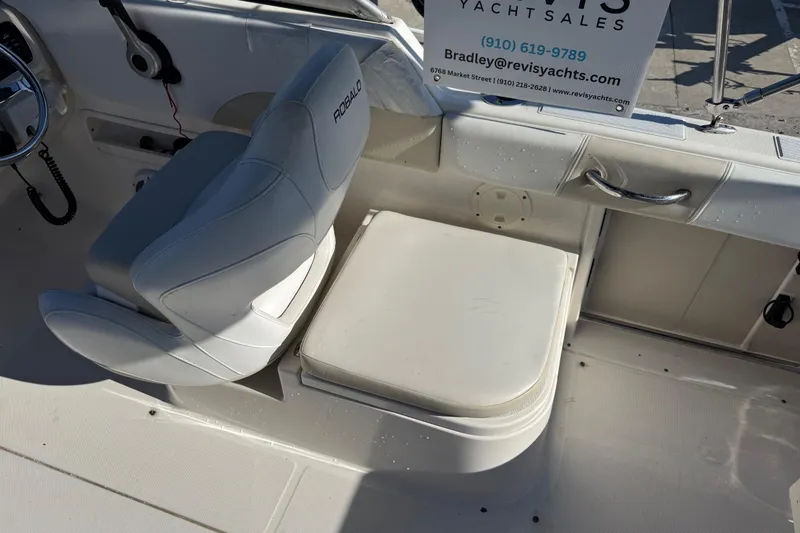 Slide: The Image of 2015 Robalo R227 Dual Console boat interior with white seating and steering wheel. - 21